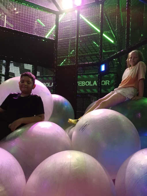 Two young people stop to smile for the camera in the bouncy ball pit!