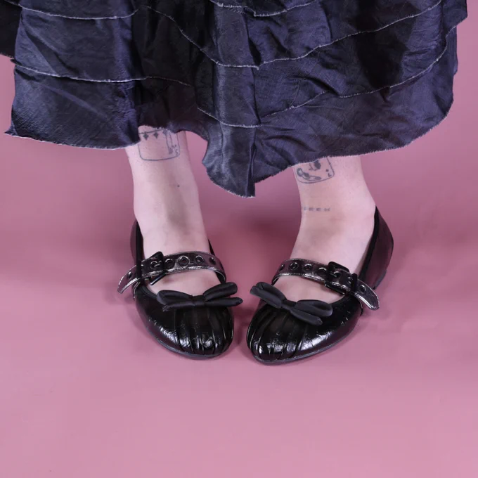 Irregular Choice 'Ballet Babe' shoes. Black patent ballet pumps with a large black bow and a metallic buckle.
