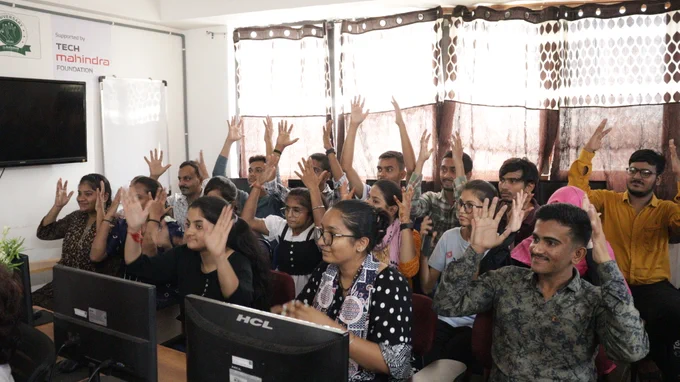 Students all smiles with their hands up in the air