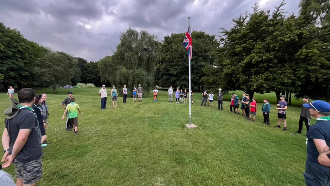 Scouts standing around a flagpole on a field