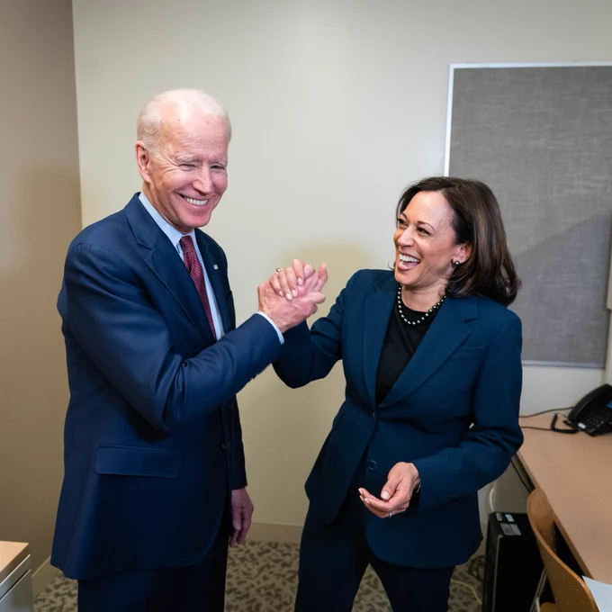 President Joe Biden and Vice President Kamala Harris laughing and giving each other a high-five.