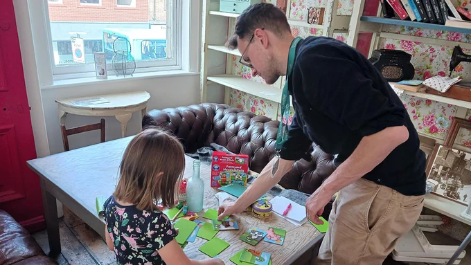 A BookTrust staff member playing a card game with a child in kinship care