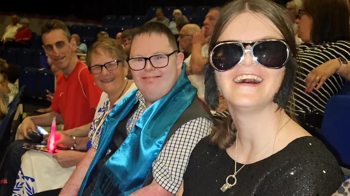 Residents excitedly waiting for the show to begin, props in hand.
