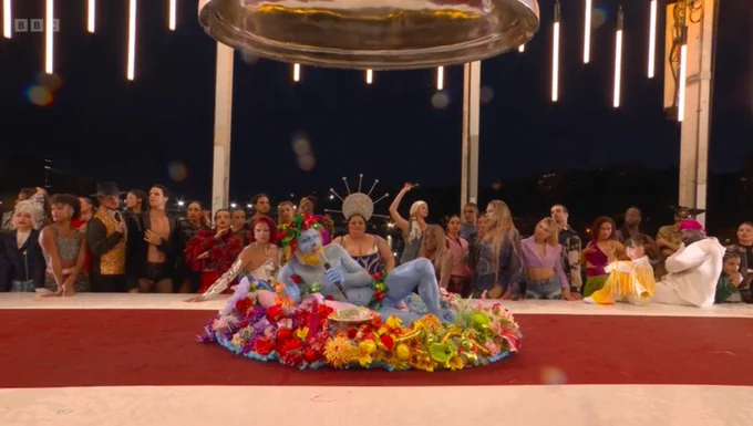 a completely blue man appears from a salad on a bridge during the Olympics