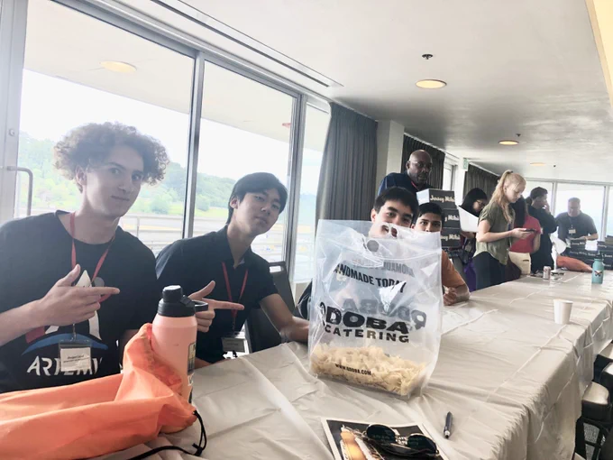people pointing to a bag of qdoba chips