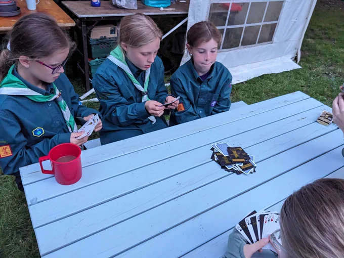 Scouts sat on a bench playing cards