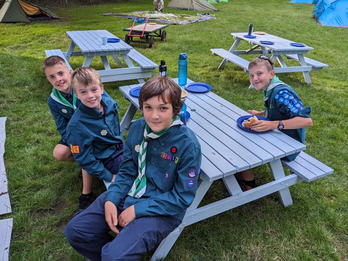 Scouts sitting on a bench smiling