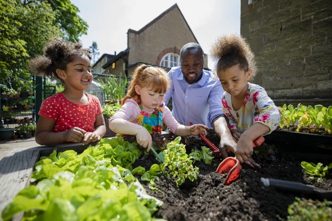 three children and an adult gardening