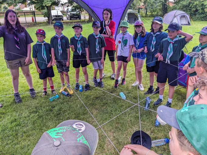 Cubs in a circle with some holding string to make a web