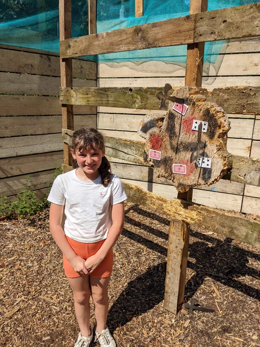 A Cub Scout in front of a tomahawk target 