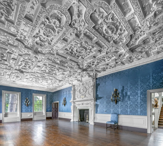 A photograph of the interior of a Jacobean manor house with extravagant plaster ceiling.