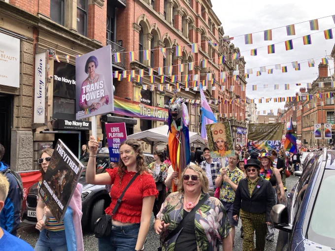 People marching at Pride with a 'Trans Power' placard