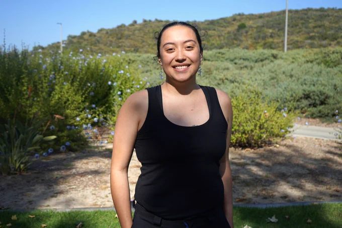 Person standing in front of a hill.