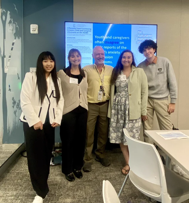 UNC students (Yinuo Xu, Emma Dear, Emma Grace Choplin, and Cameron Thomas) presenting a research poster with Dr. Eric Youngstrom.