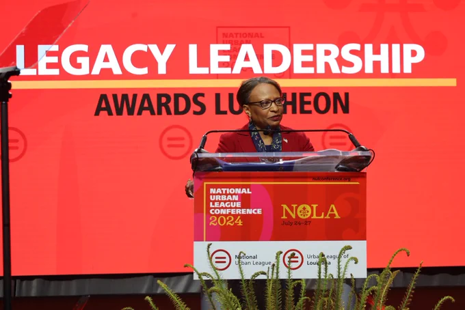 A photo of Acting Secretary Todman speaking at a podium.