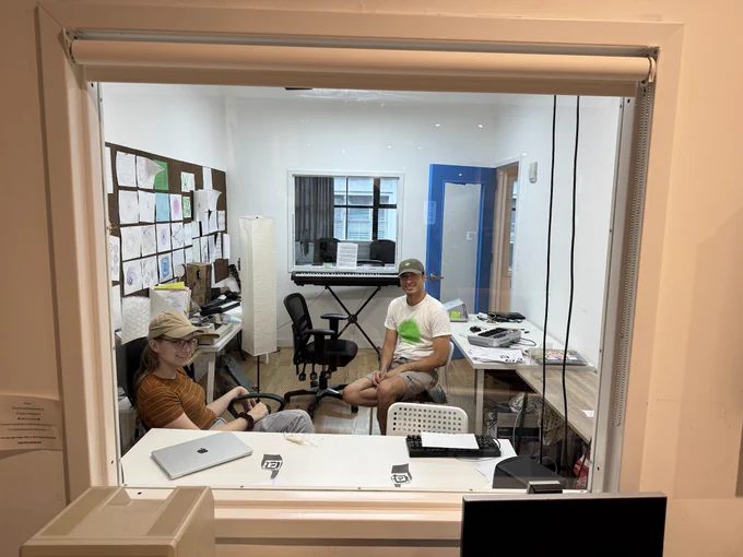 Jessie Grosen and Omar Rizwan sitting in the Recurse room with the Recurse Folk Computer system