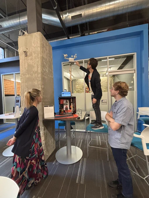 Student Chris Rogers demonstrates his weather station for two other students