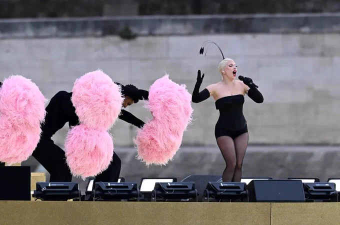 Lady Gaga is surrounded by giant pink pompom wielding dancers at the opening ceremonies for the 2024 Paris Olympics in this photo 