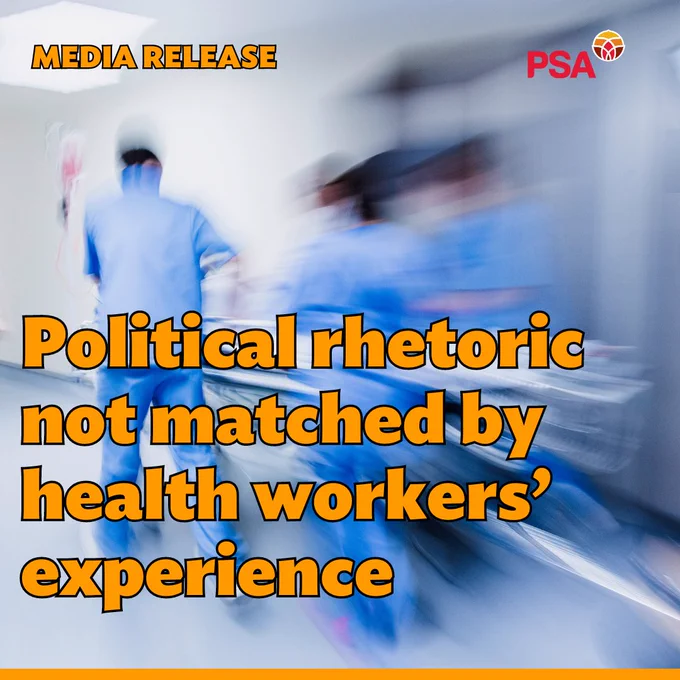 The Image is inside a hospital corridor with three blurred figures in blue hospital scrubs in motion pushing a hospital bed. “MEDIA RELEASE” is in the top left-hand corner in orange. A red PSA logo is in the top right. Beneath is the headline “Political rhetoric not matched by health workers’ experience” in large orange text.