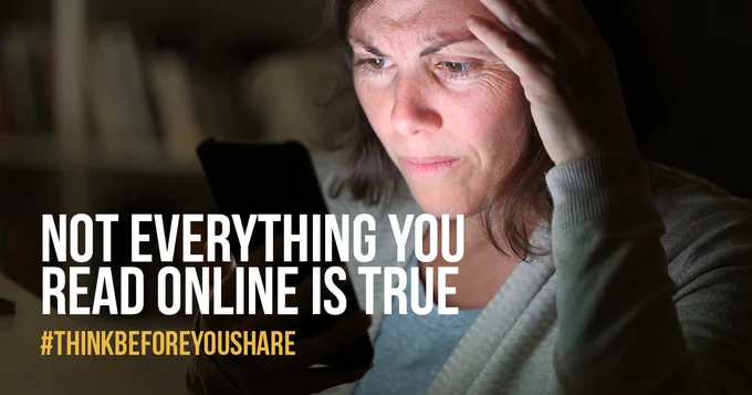 Woman looks worried whilst reading something on her phone. Not everything you read online is true.