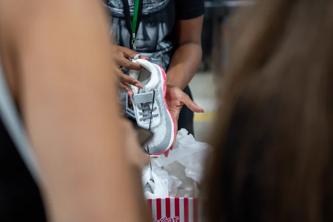 Hands holding a tennis shoe
