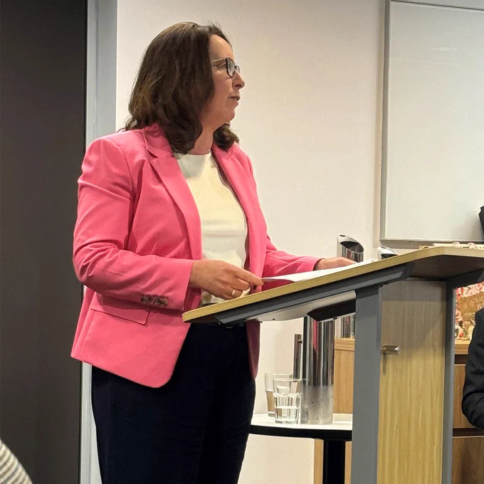 Angelene Falk standing at lectern