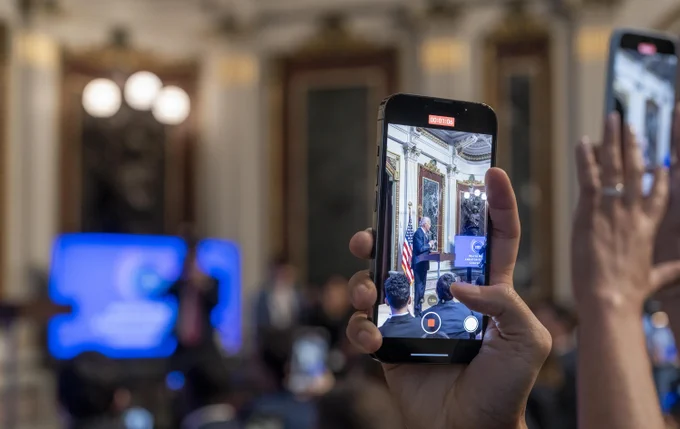 An event attendee captures content of the President delivering remarks at the first-ever White House Creator Economy Conference.