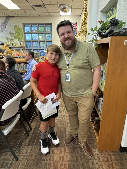 Boy standing with adult and smiling