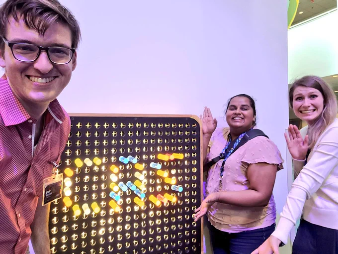 A few Future Leaders collaborating to make a CAS sign at COSI using colored pegs on a light-up board