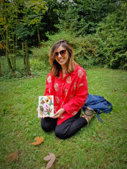Indian woman in a park making nature art using fallen leave and twigs etcetera