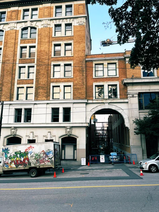A cool busted up truck that is also spray painted, and, also an alley