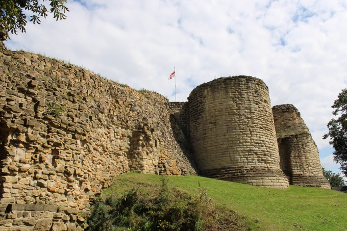 Part of the remains of Pontefract Castle keep and curtain wall, with the St George's flag flying above the keep