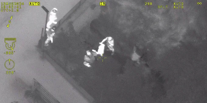 Thermal Image of a person being detained by police officers.