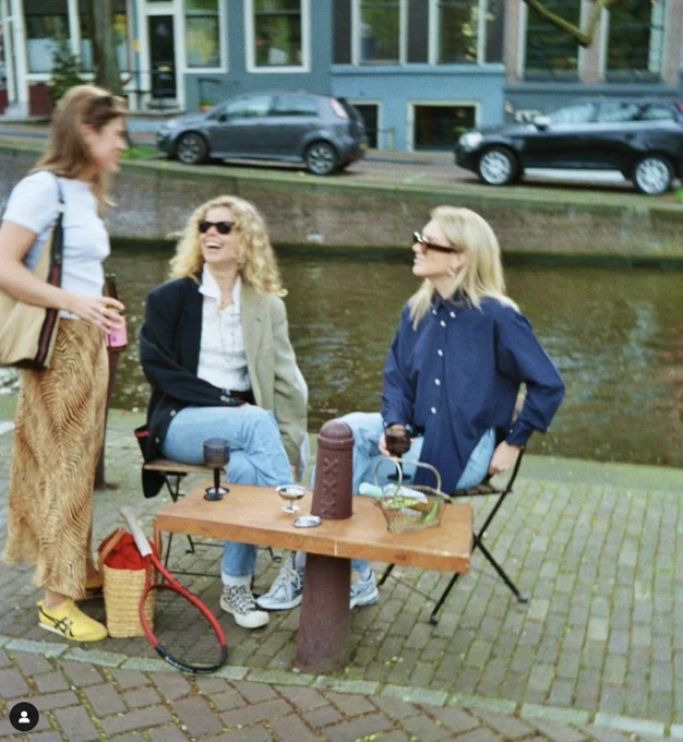 Friends enjoy wine using a bollard table in Amsterdam