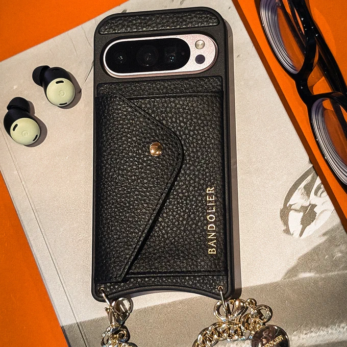 Rose Quartz Pixel 9 in a Bandolier phone case next to a pair of glasses and Lemongrass Pixel Buds.