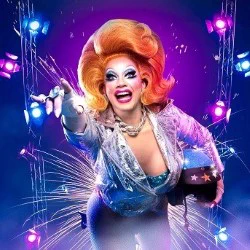 A ginger drag queen flies into view
