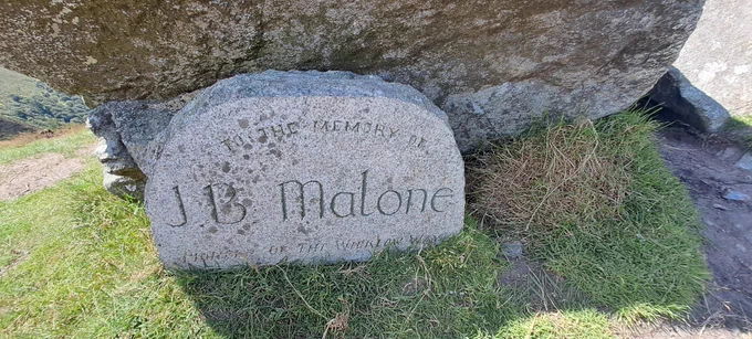 Following his passing in 1989, a memorial was erected as a tribute to this remarkable man along the Wicklow Way overlooking Lough Tay. Carved by sculptor Billy Gannon and erected in 1990,

You can read more about this remarkable man and Defence Forces veteran in the book: J.B. Malone The Life and Times of a Walking Pioneer and an Explorer of the Nearby, by Michael Fewer available at South Dublin Libraries.