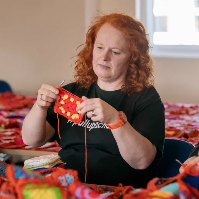 Dr Sarah Martin-Denham from the University of Sunderland holding a square of the crocheted blanket