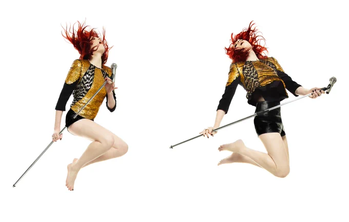 Two photos of the same woman side by side. She holds a microphone stand and jumps, throwing her bright red hair in the air. 