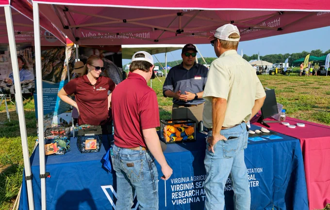 Jonathan van Senten and Tiffany Wood (VSAREC) speak with attendees at the Virginia Ag Expo.