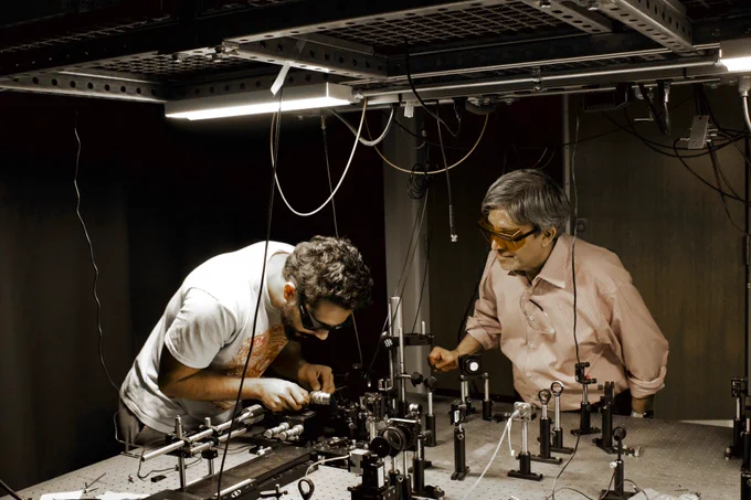 Nitin Samarth and student Jyotirmay Dwivedi work in an optics lab.