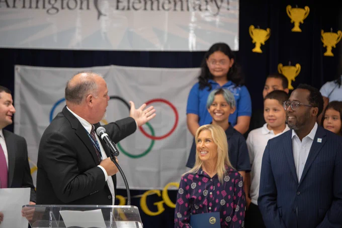 a person turning and showing kids on a stage