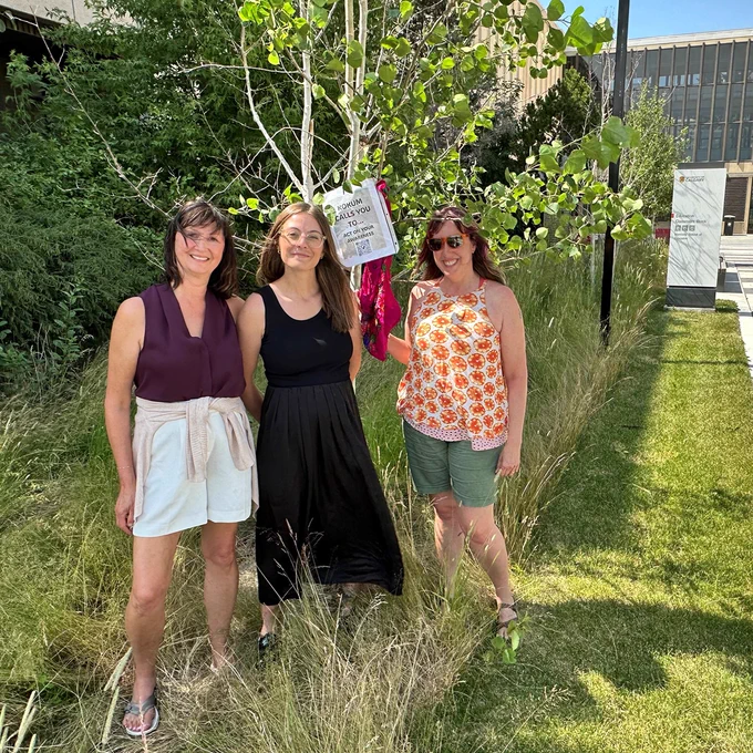 Yvonne Poitras Pratt and Werklund School graduate students Natalie Lauchlan and Nicole Cameron display kokum scarves on trees around the Education Tower and Classroom Block.