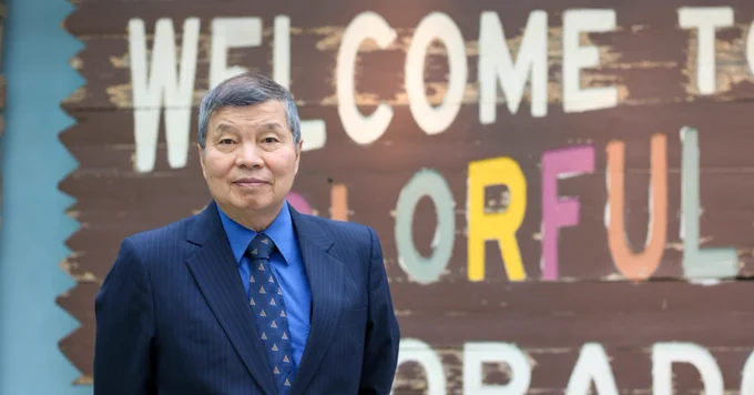 Dr. William Wei in front of a sign that reads Welcome To Wonderful Colorado