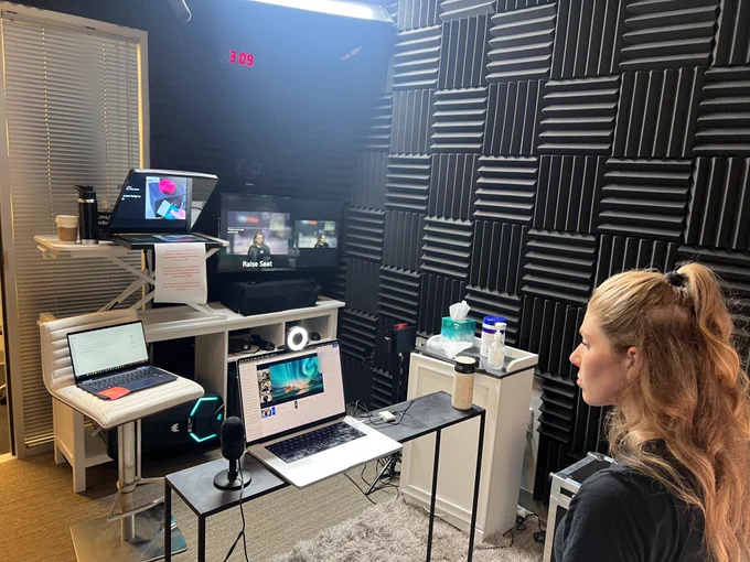 Rebecca sitting in a video booth behind a computer