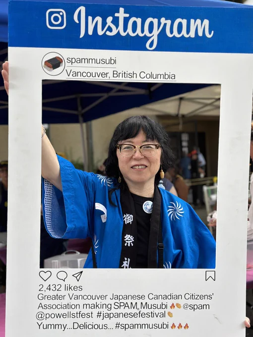 Lorene in happi coat holding  an Instagram frame with info about GVJCCA spam musubi