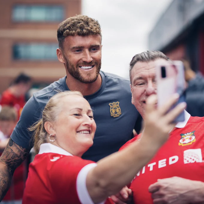 Dan Scarr having a photo with two fans outside of the ground