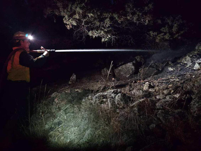A wildland firefighter works through the night on the Badland Complex in Oregon.
