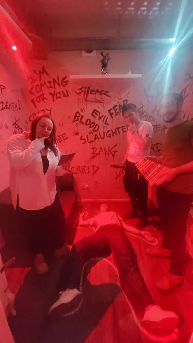 Photo of me lying on the floor in a chalk outline while three people stand over me