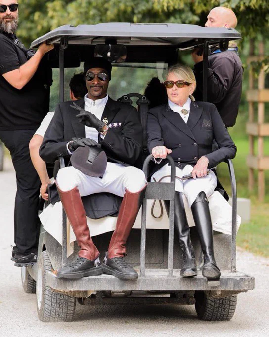 Snoop Dogg and Martha Stewart in full equestrian regalia sit on the back of a golf cart at the Paris Olympics.